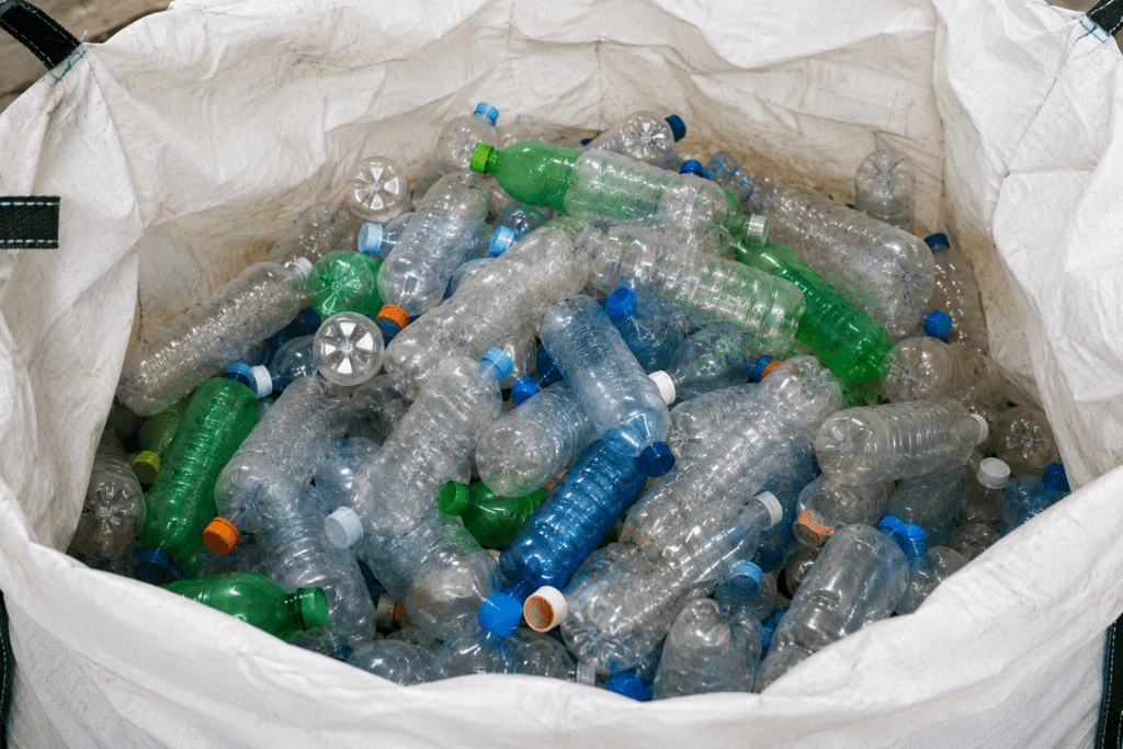 Botellas PET reciclables transparentes y de color almacenadas para procesos de reciclaje y aprovechamiento industrial en Bogotá.